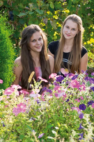 Tiener meisjes op een achtergrond van bloemen — Stockfoto