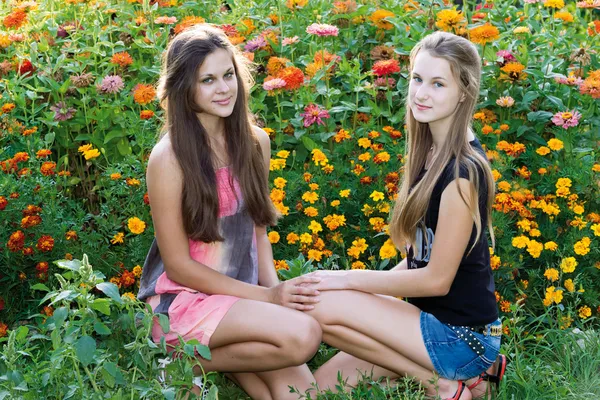 Nastolatki dziewczyny na tle kwiatów — Zdjęcie stockowe