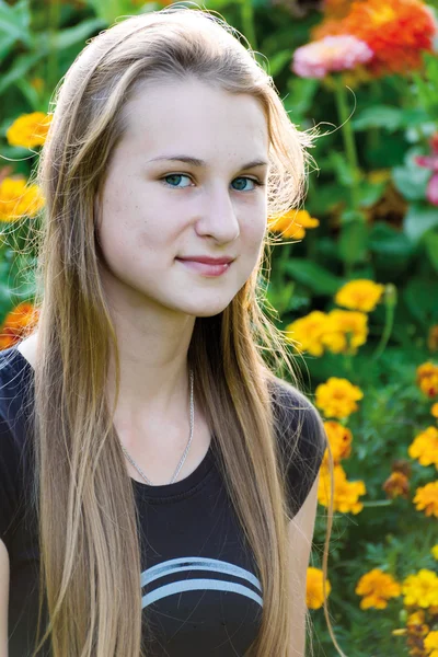 Menina adolescente em um fundo de flores — Fotografia de Stock