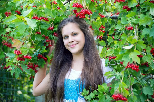 赤いガマズミ属の木の近くの十代の少女 — ストック写真
