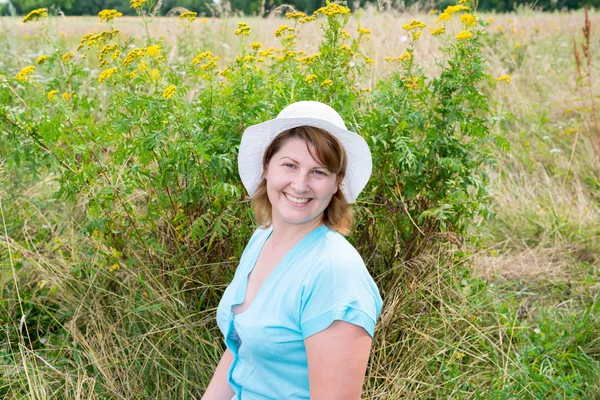 Femme d'âge moyen sur une prairie avec tanaisie — Photo