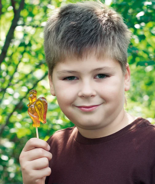 Мальчик с леденцом на природе — стоковое фото