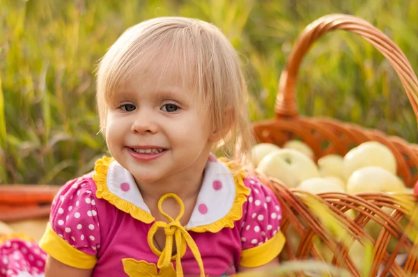 Little girl with a basket of fresh apples — Stock Photo, Image