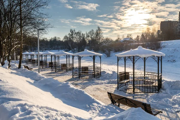 Fila de gazebos de metal em banco de lagoa congelada, Rússia — Fotografia de Stock