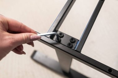 Bir kadının elindeki metal profilin allen anahtarı.