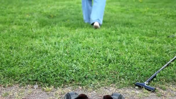 Yaşlı bir adamın bacakları dışarı gidiyor çıplak ayakla çimlerde — Stok video