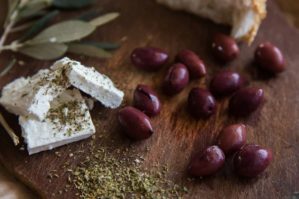 Olives on a wooden table and feta cheese Royalty Free Stock Photos