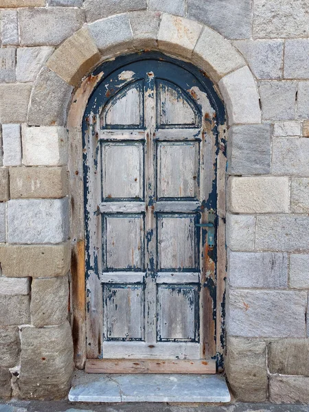非常古老的门在石墙上涂着剥落的蓝色油漆 — 图库照片