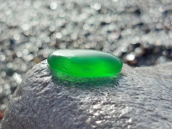 Egy Zöld Üvegdarab Melyet Tenger Csiszolt Egy Nagy Szürke Kövön — Stock Fotó