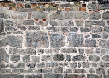 Antik evin duvarının farklı boyutlarda gri taşlardan yapılmış bir parçası. Yatay çekim. 