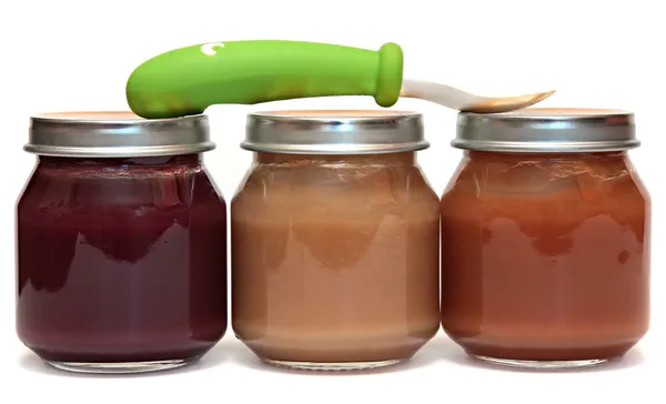 Tres frascos de comida para bebés y cuchara aislados sobre un fondo blanco . —  Fotos de Stock