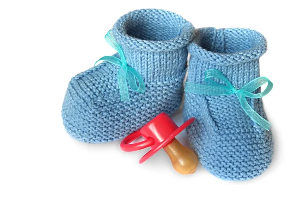 Par de botas de malha azul para crianças e boneco de bebê em um fundo branco — Fotografia de Stock