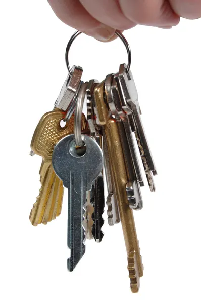 Bunch of metal keys isolated on a white background. The human hand that holds the keys. — Stock Photo, Image