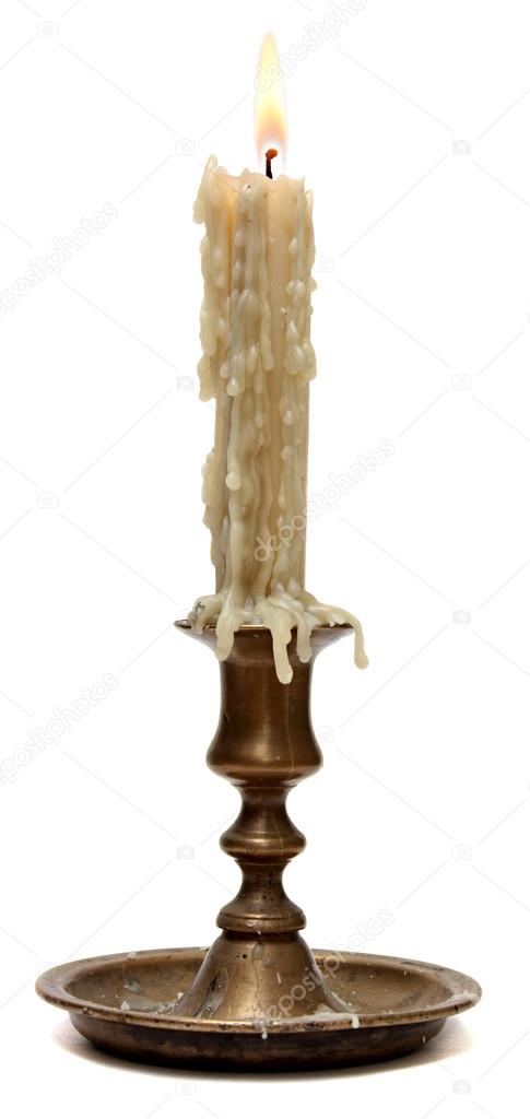 Burning old candle vintage bronze candlestick. Isolated on a white background.