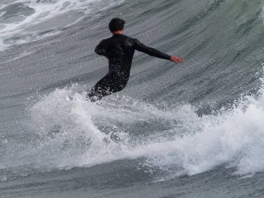 Bir sörfçü İtalya 'da bir dalgada sörf yapar