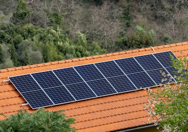 在波兰的一个城市 阳光明媚的时候 在黑暗的房顶上安装了迷你蓝色太阳能电池板 图库图片