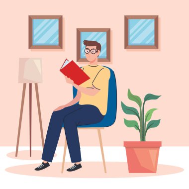 Adam oturmuş kitap okuyor.