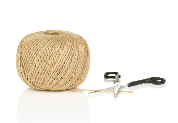 Bola de corda natural com extremidade solta e tesouras em fundo branco com reflexão — Fotografia de Stock