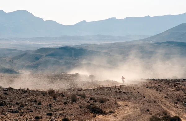 Bicicleta cruzar un desierto de piedra . — Foto de Stock
