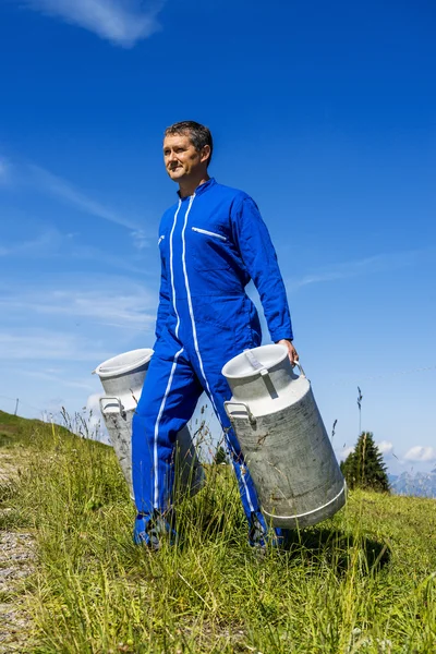 Agricoltore con contenitori di latte — Foto Stock