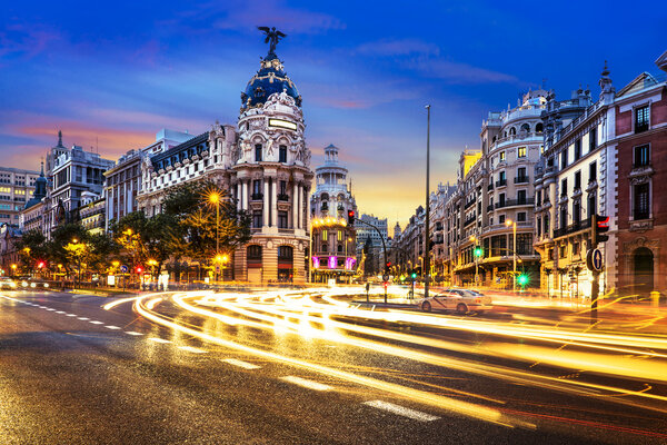 Rays of traffic lights on Gran via street, main shopping street in Madrid at night. Spain, Europe.