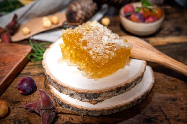 Geleneksel bir masada bıçakla kesilmiş taze bal parçası.