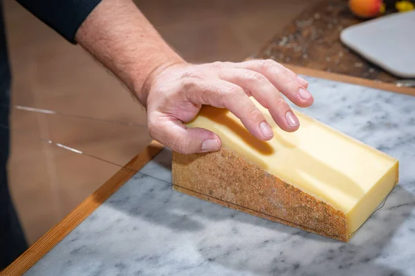 Man Cuts Portion Gruyere Wire Famous Swiss Cheese Cellar Marble — Stock Photo, Image