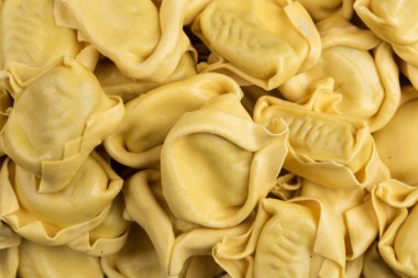 İtalyan yemeğinin tadına baktı. Arka planda Ravioli makarnası var. Üst görünüm biçimi