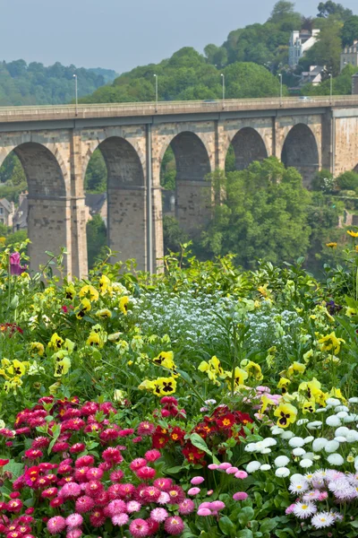 Luminoso macizo de flores y alto puente de piedra —  Fotos de Stock