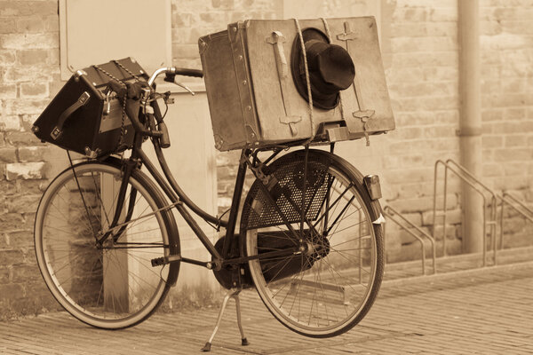 Shabby black hat and suitcases on the bike