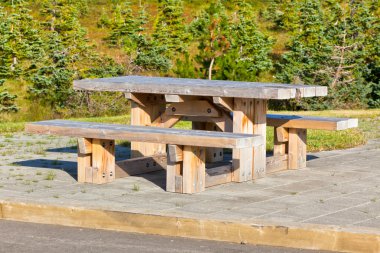 Wooden table and benches in resting area clipart
