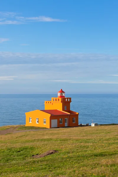 Zee landschap met oranje vuurtoren en blauwe hemel — Stockfoto