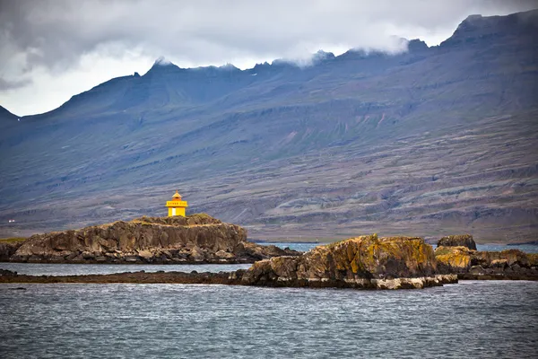 Island Meer und Gebirgslandschaft mit orangefarbenem Leuchtturm — Stockfoto