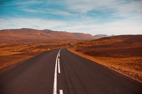 Snelweg door droge grind lava veld landschap onder een blauwe som — Stockfoto