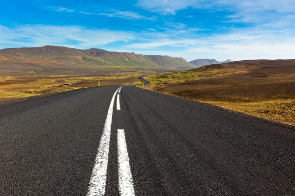 Estrada através de cascalho paisagem campo de lava sob um verão azul — Fotografia de Stock