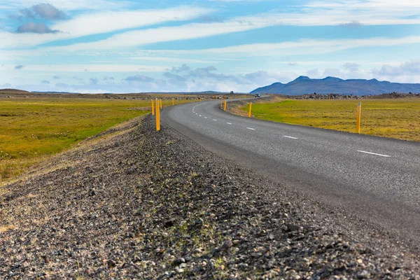 Motorvägen genom Isländska landskapet under en blå sommarhimmel — Stockfoto