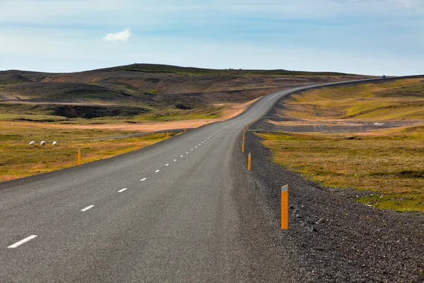 Motorvägen genom Isländska landskapet under en blå sommarhimmel — Stockfoto