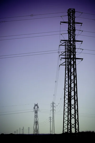 Elektriciteit macht pylonen silhouetten — Stockfoto