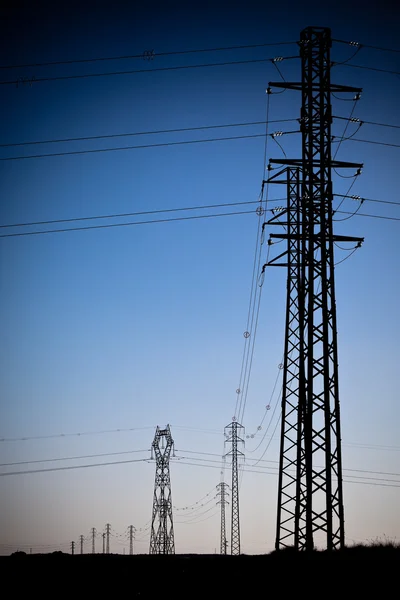 Elektriciteit macht pylonen silhouetten — Stockfoto