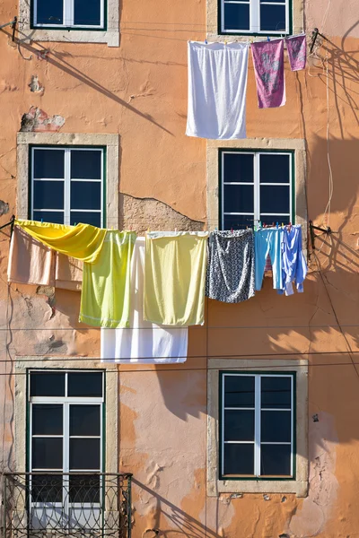 Praní visí venku staré budově Lisabon, Portugalsko — Stock fotografie