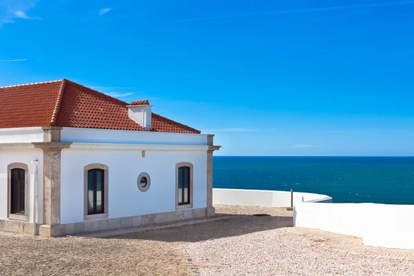 Turquoise zee, blauwe hemel en witte huis in portugal — Stockfoto