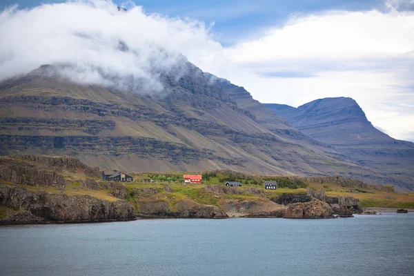Izlandi táj: házak a ködös hegyek — Stock Fotó
