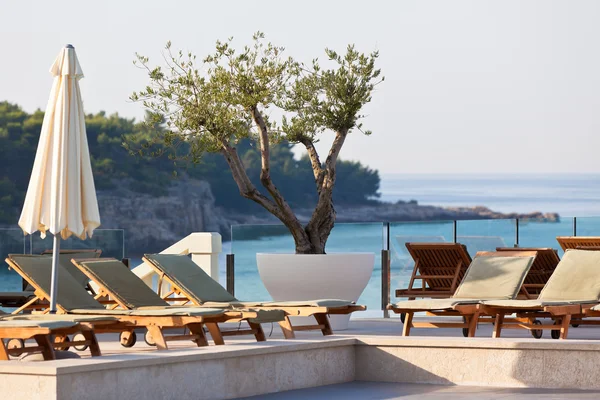 Hotel zwembad stoelen met uitzicht op zee — Stockfoto