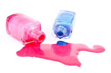 Beyaz arka planda dökülmüş ojeli şişeler.