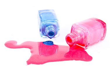 Beyaz arka planda dökülmüş ojeli şişeler.