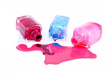 Beyaz arka planda dökülmüş ojeli şişeler.