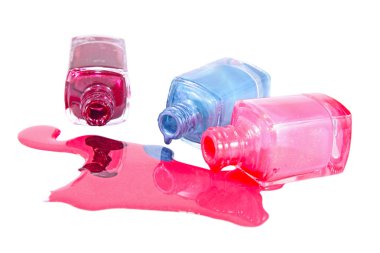 Beyaz arka planda dökülmüş ojeli şişeler.