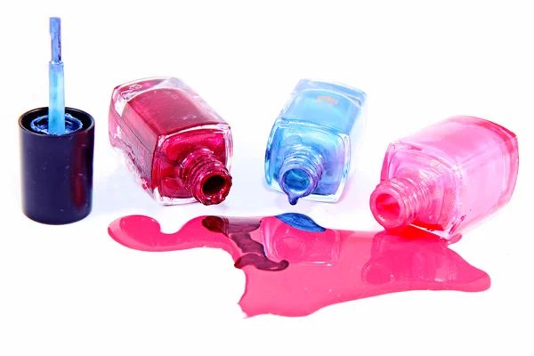 Butelki z rozlanym lakierem do paznokci na białym tle — Zdjęcie stockowe
