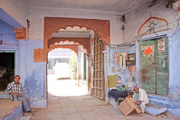 Індійський чоловік у вікні синій будинку в місті Jodhpur — стокове фото