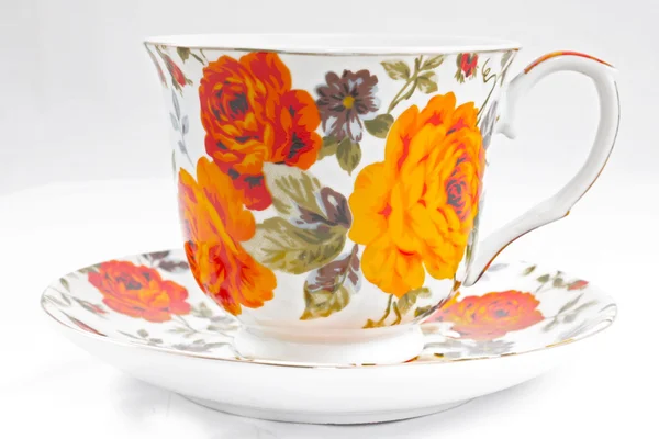 Klassische Teetasse mit roten und orangen Blüten — Stockfoto